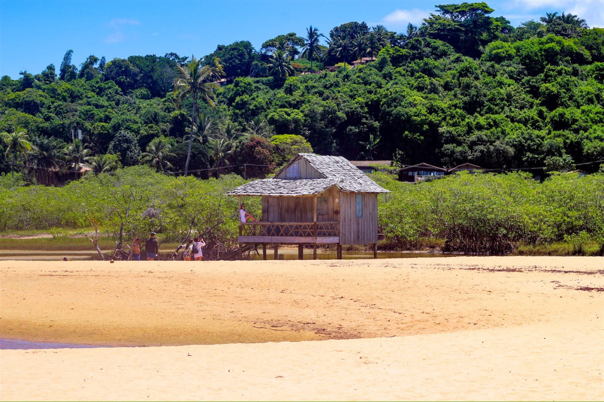 Palafita de madeira à beira do rio na Praia dos Nativos