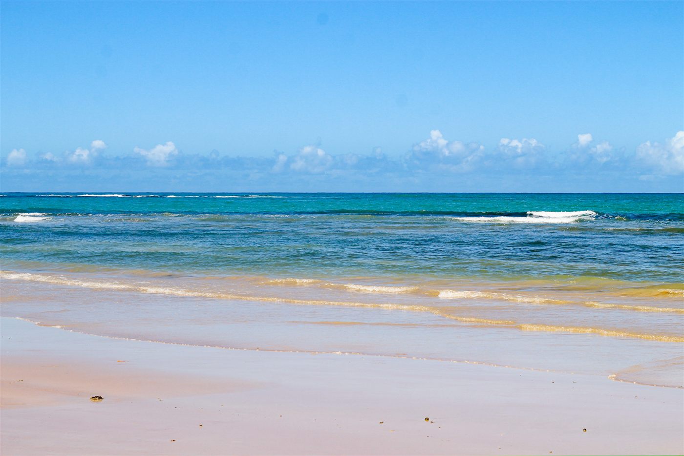 Mar azul e areia clara em dia ensolarado na região de Porto Seguro
