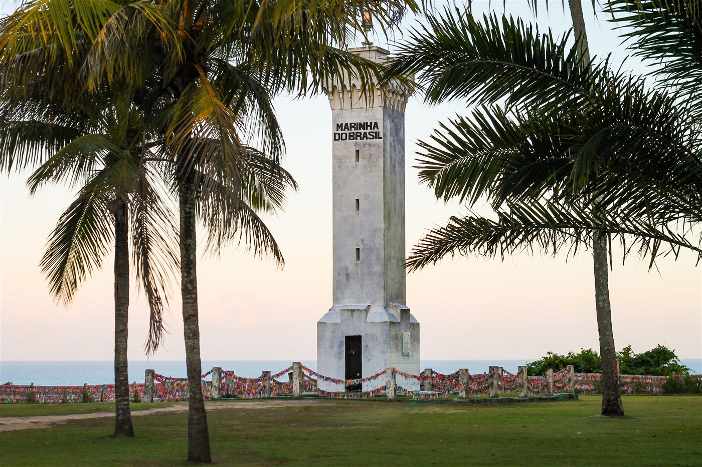 Farol da Cidade Histórica de Porto Seguro entre coqueiros ao entardecer
